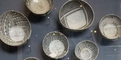 Ancient ceramic pottery shards displayed on a dark surface